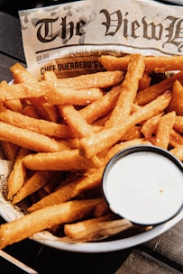 A vibrant plate with crispy golden fries and a side of homemade dipping sauce.