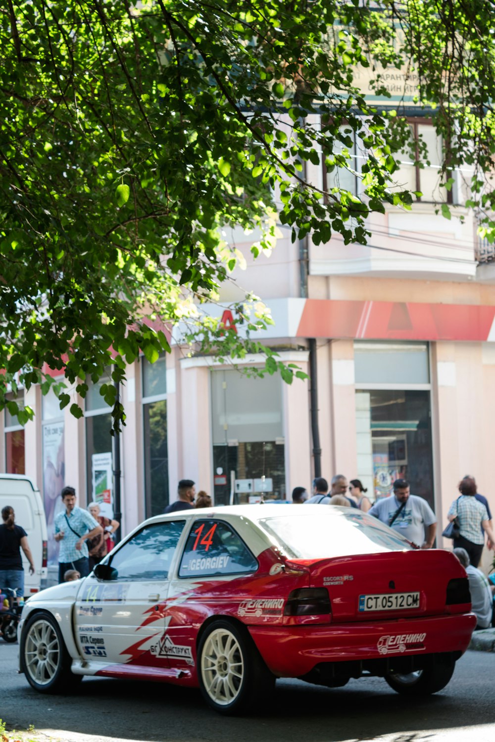 red and white car in front of white building during daytime