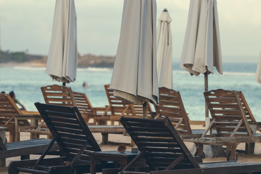 sedie di legno marrone sulla spiaggia durante il giorno