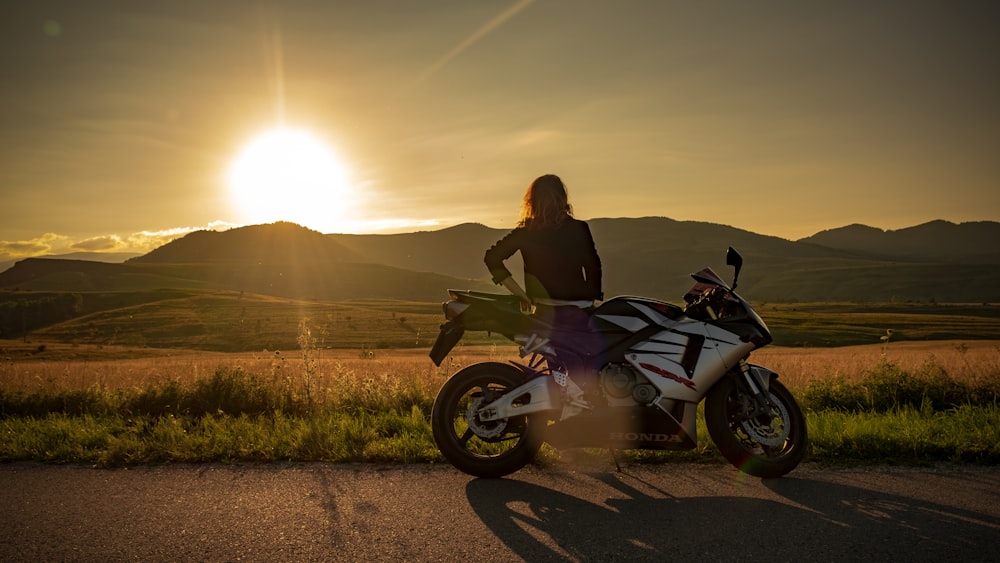 woman riding on black and white motorcycle during daytime