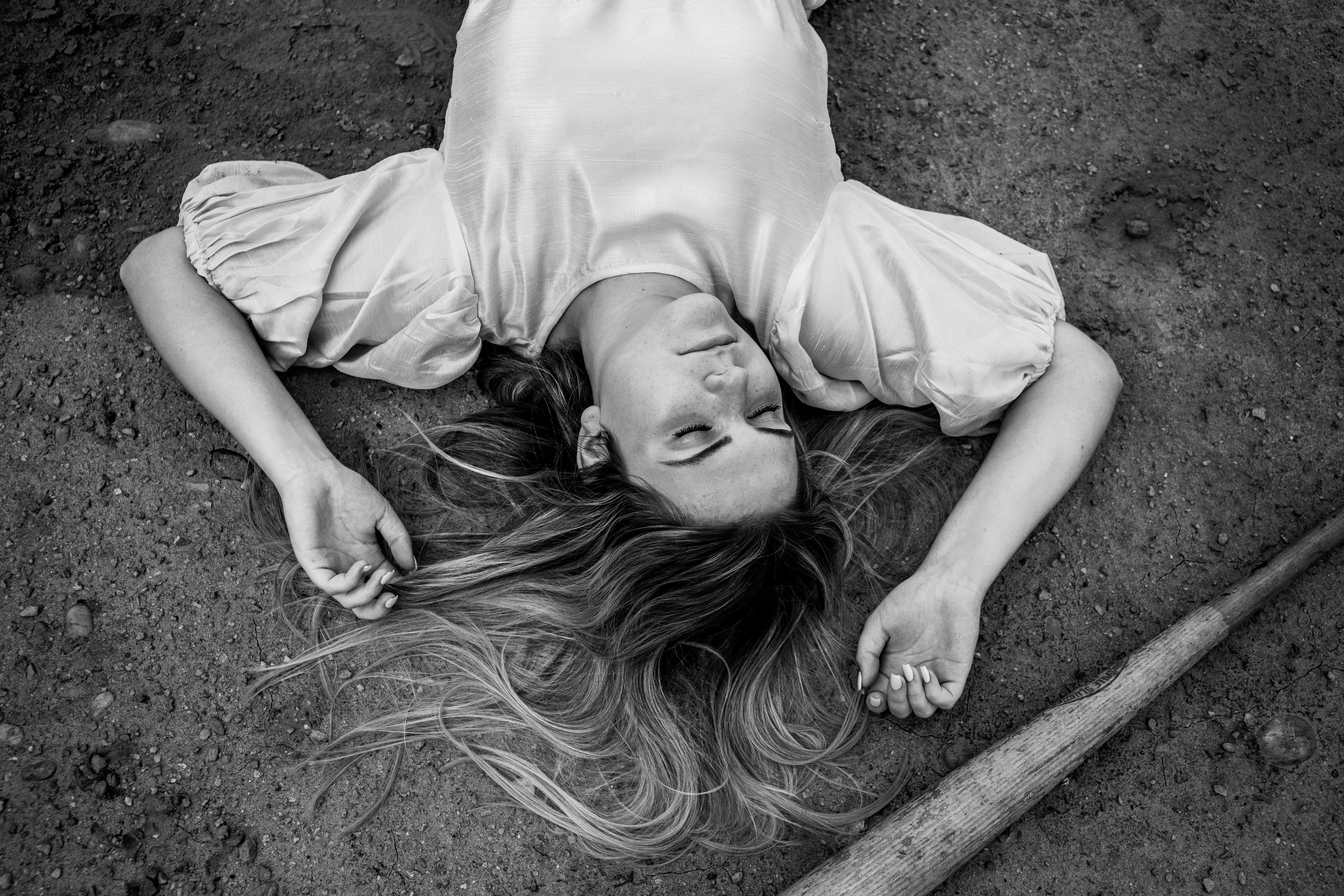 woman in white t-shirt lying on ground