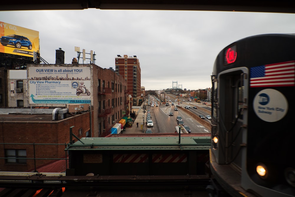 black train on rail road near city buildings during daytime