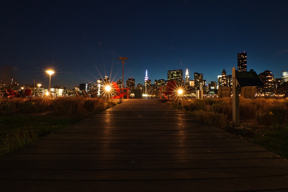 people walking on wooden pathway during night time