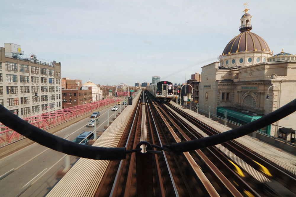 brown wooden train rail near city buildings during daytime