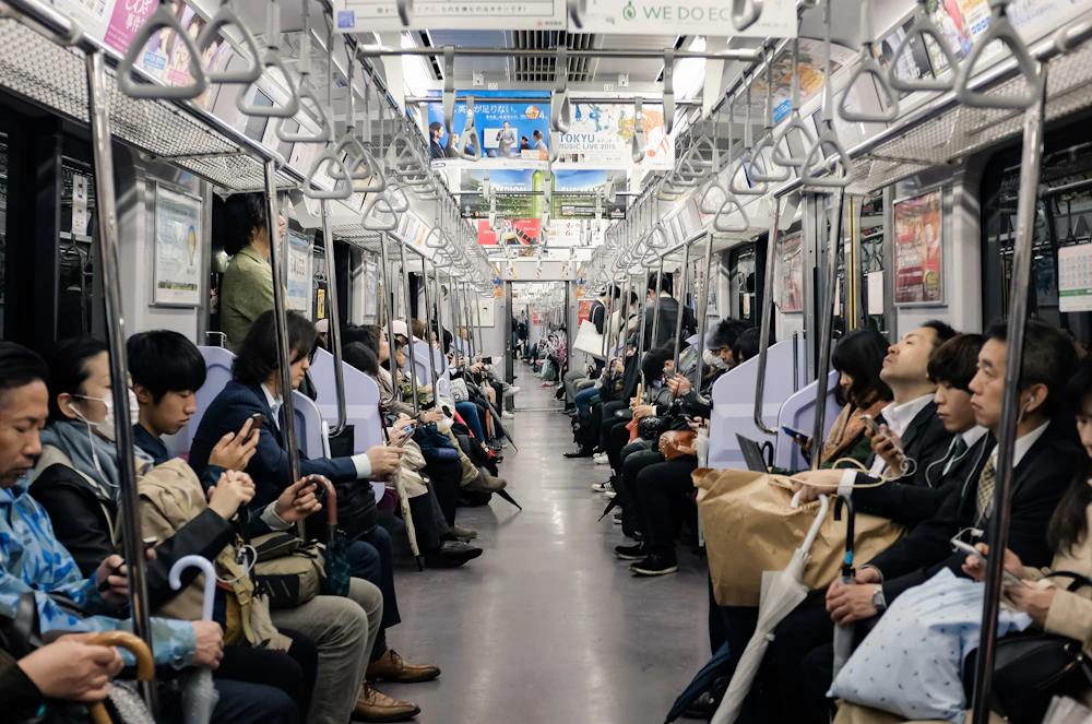 The quiet interior of a Japanese commuter train with seated passengers
