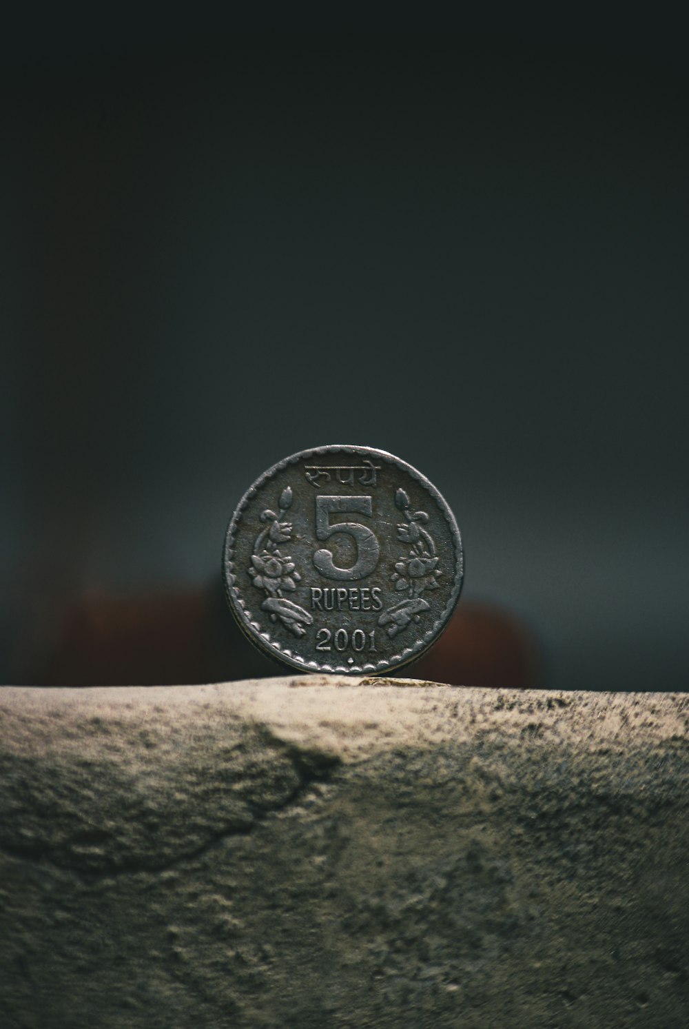 moeda redonda de prata na superfície marrom do concreto