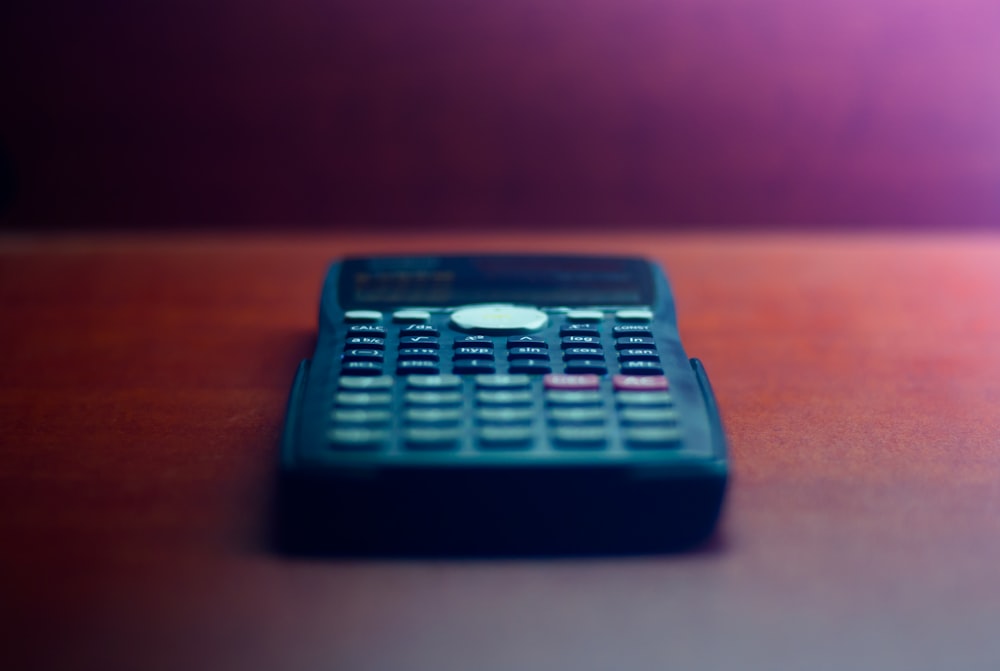 black desk calculator on brown wooden table