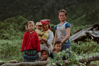 family sitting on brown wooden bench during daytime