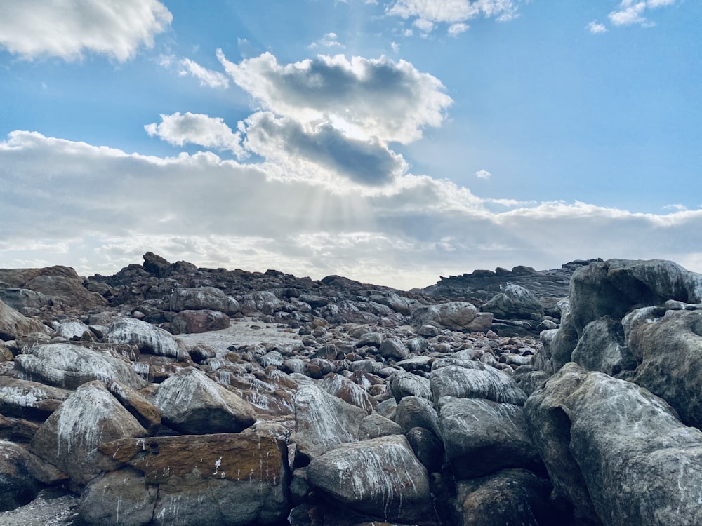 rocky shore under blue sky and white clouds during daytime