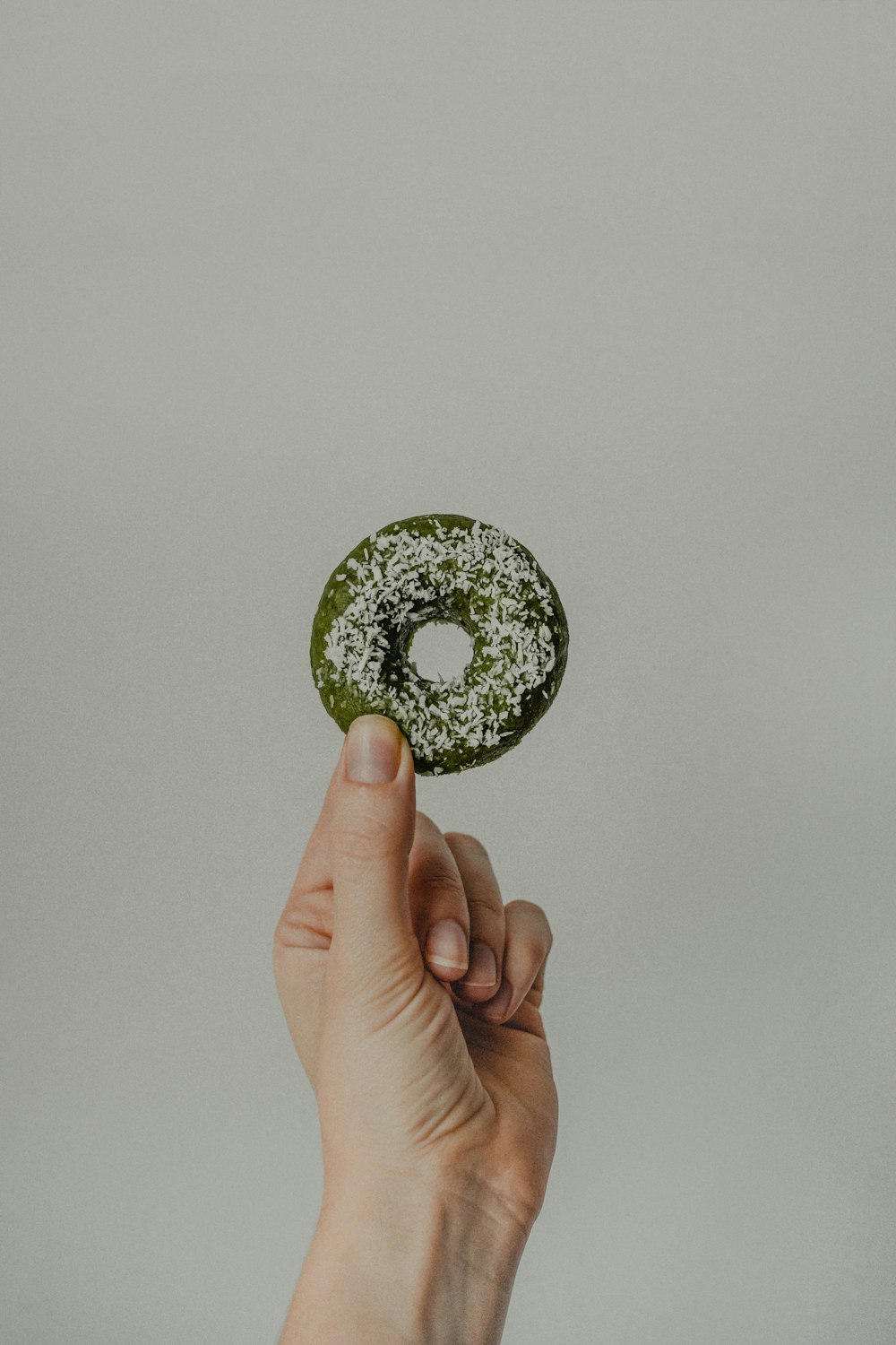 person holding green and black round ornament