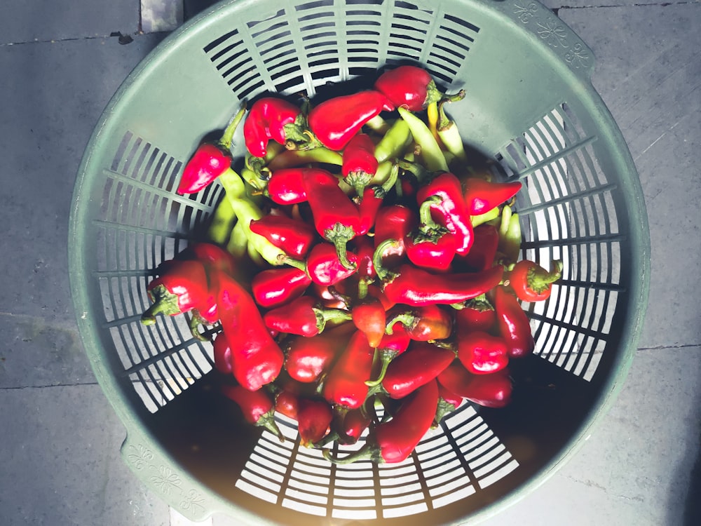 red and green bell peppers in blue plastic basket