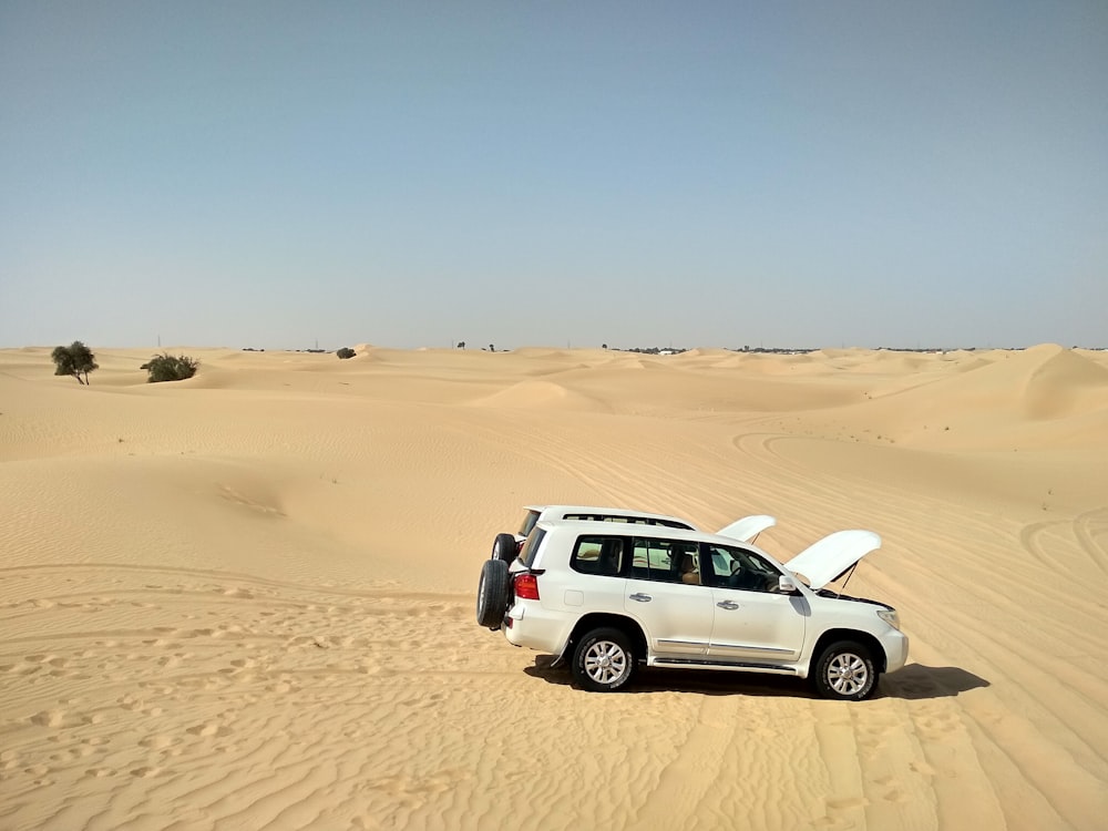 white suv on desert during daytime