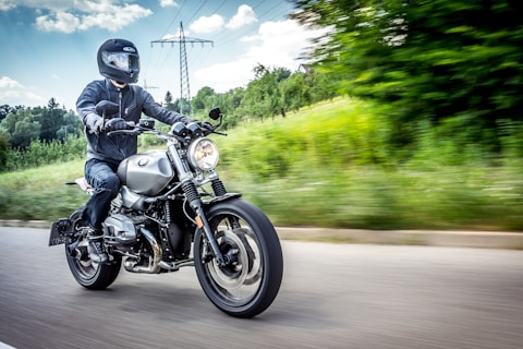 man in black motorcycle helmet riding motorcycle on road during daytime