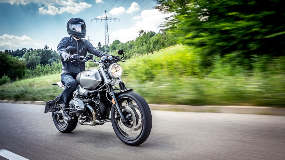 man in black motorcycle helmet riding motorcycle on road during daytime