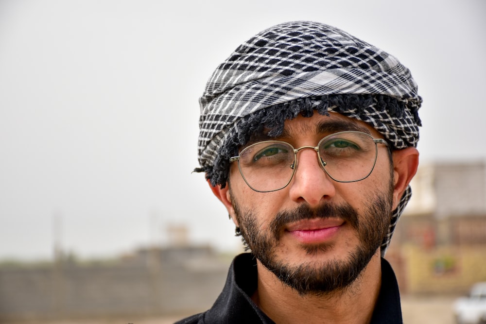 homme en bonnet en tricot noir et blanc et lunettes à monture noire