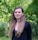 woman in black long sleeve shirt standing near green trees during daytime