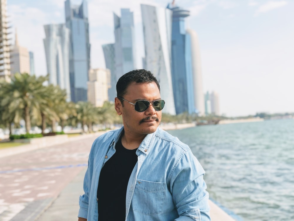 man in blue dress shirt wearing black sunglasses