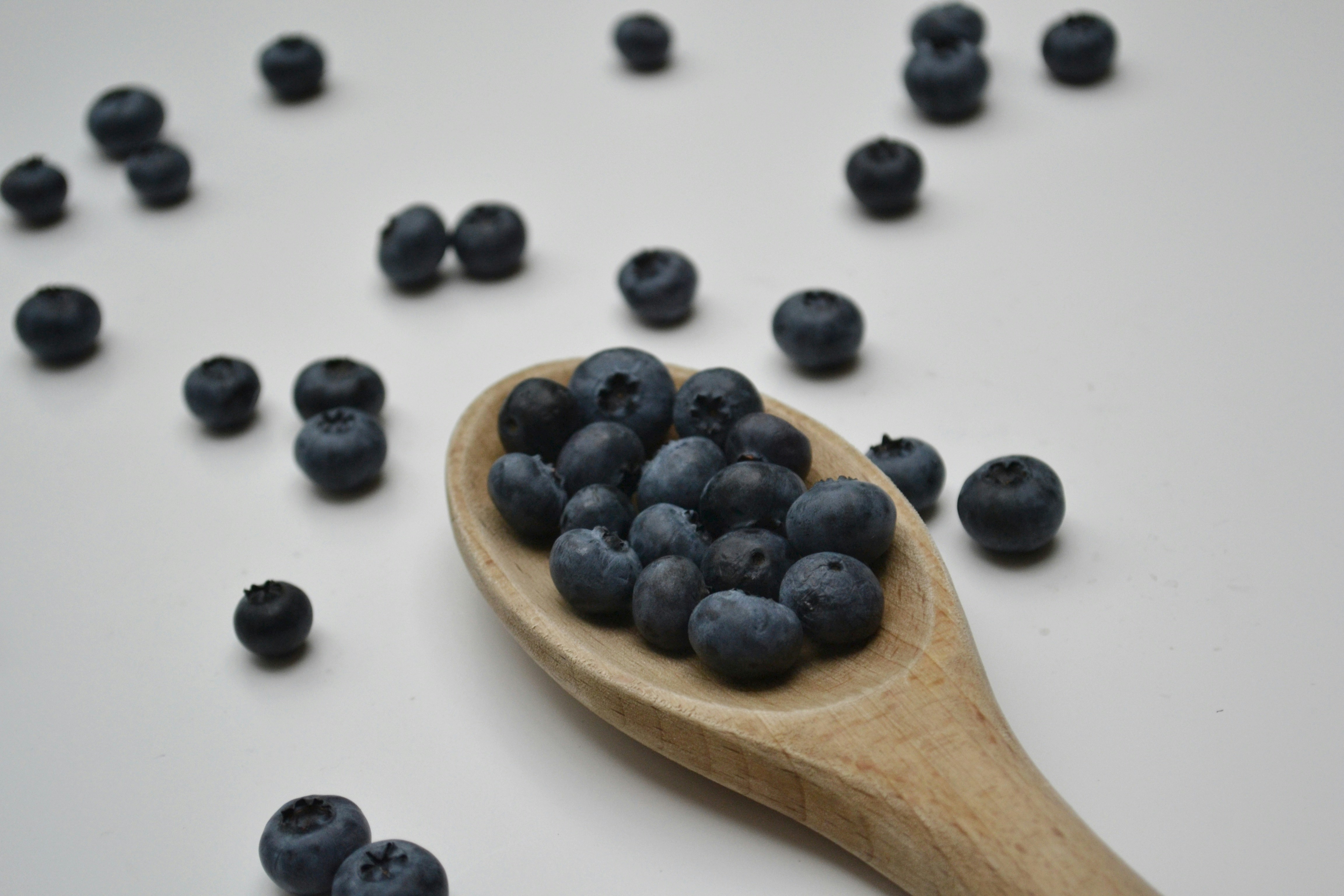 black berries on brown wooden spoon