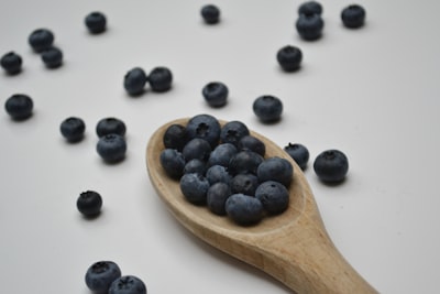 black berries on brown wooden spoon appealing zoom background