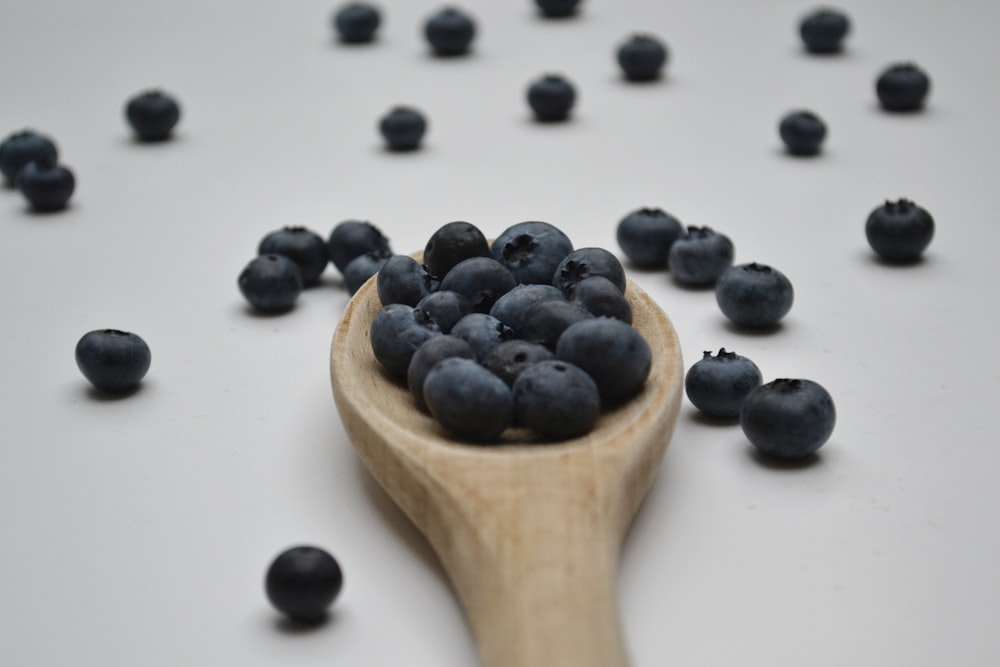 black berries on brown wooden spoon