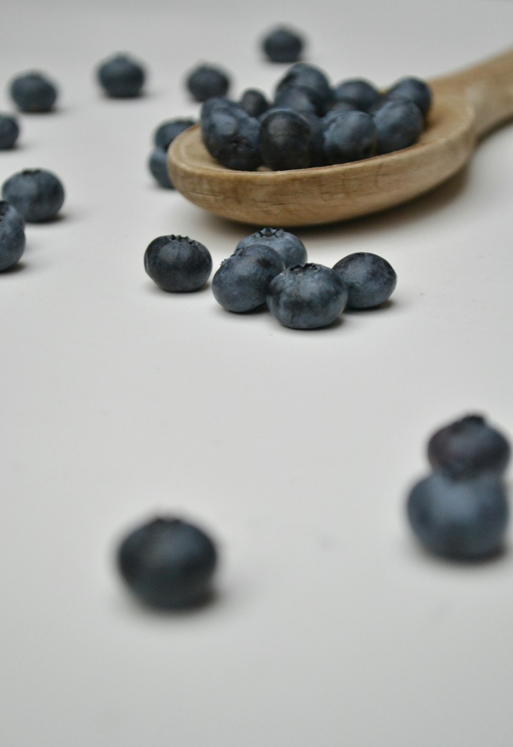 schwarze runde Früchte auf weißem Tisch