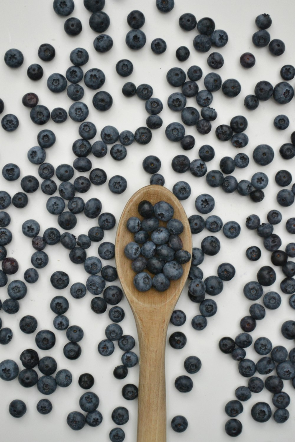 black berries on brown wooden spoon