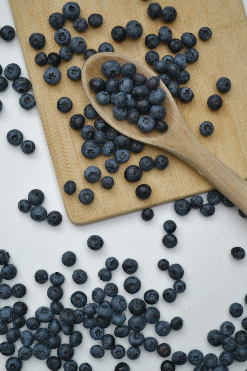 black berries on brown wooden spoon