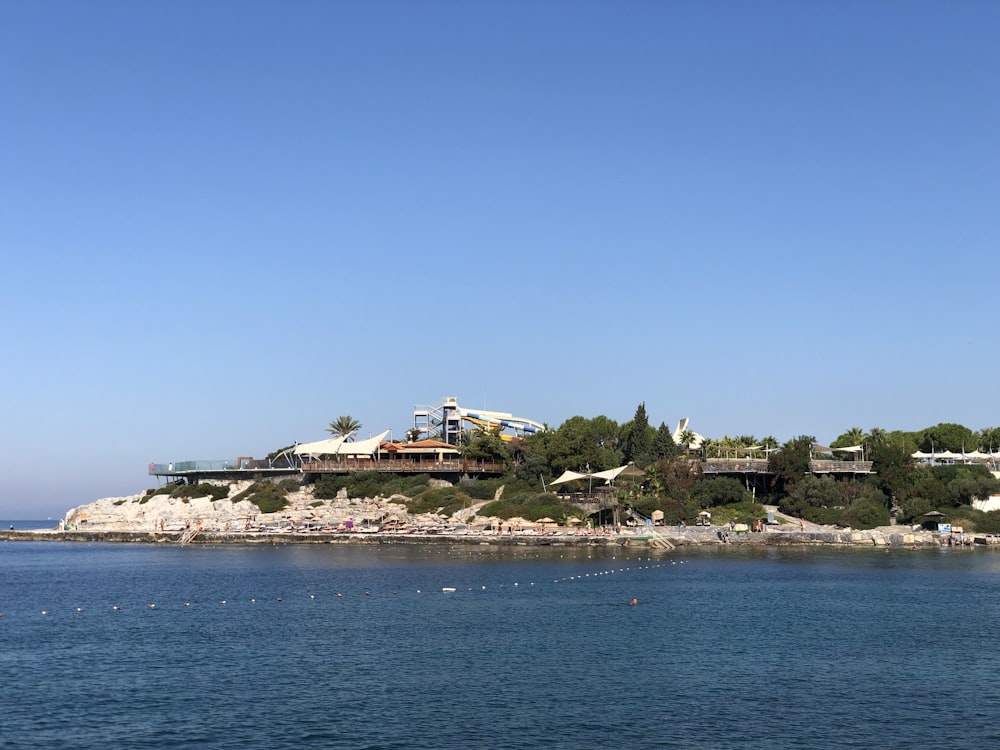 Casa bianca e marrone sull'isola circondata dall'acqua sotto il cielo blu durante il giorno