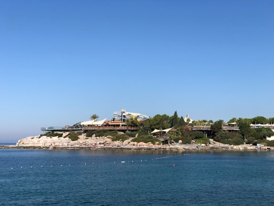 white and brown house on island surrounded by water under blue sky during daytime in Kuşadası Turkey