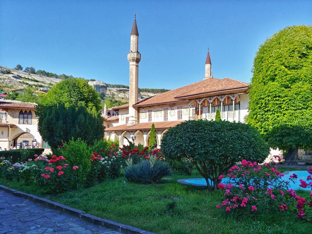 a large building with a clock tower in the middle of a garden