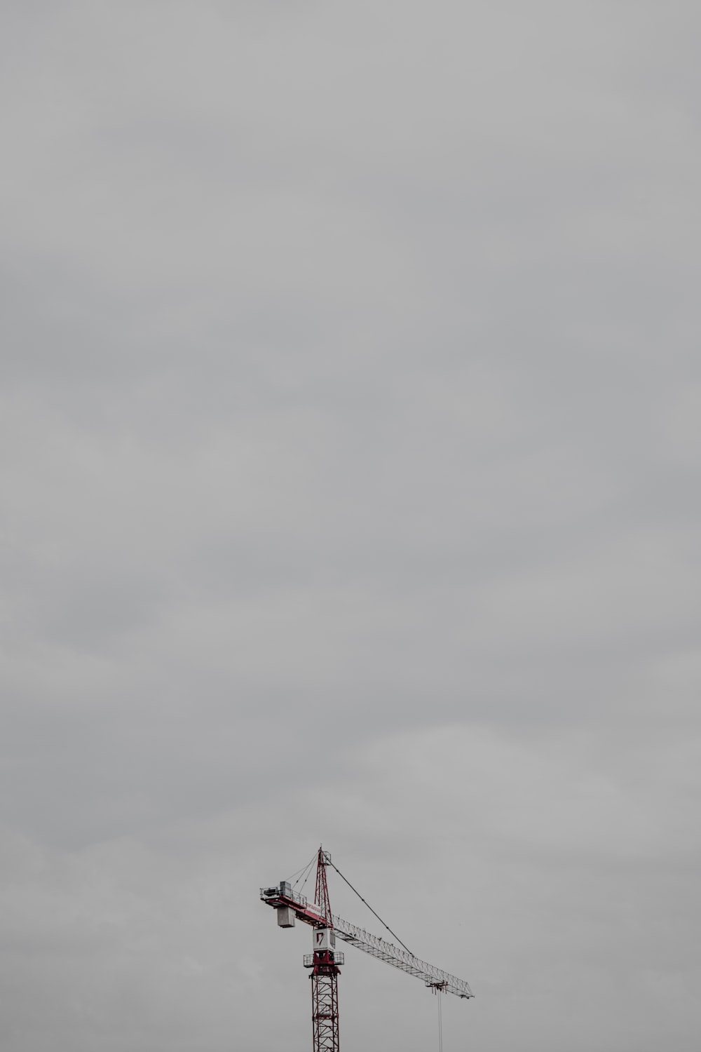 black bird flying under white clouds during daytime