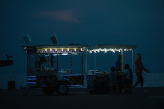 a food cart sitting on the side of a body of water