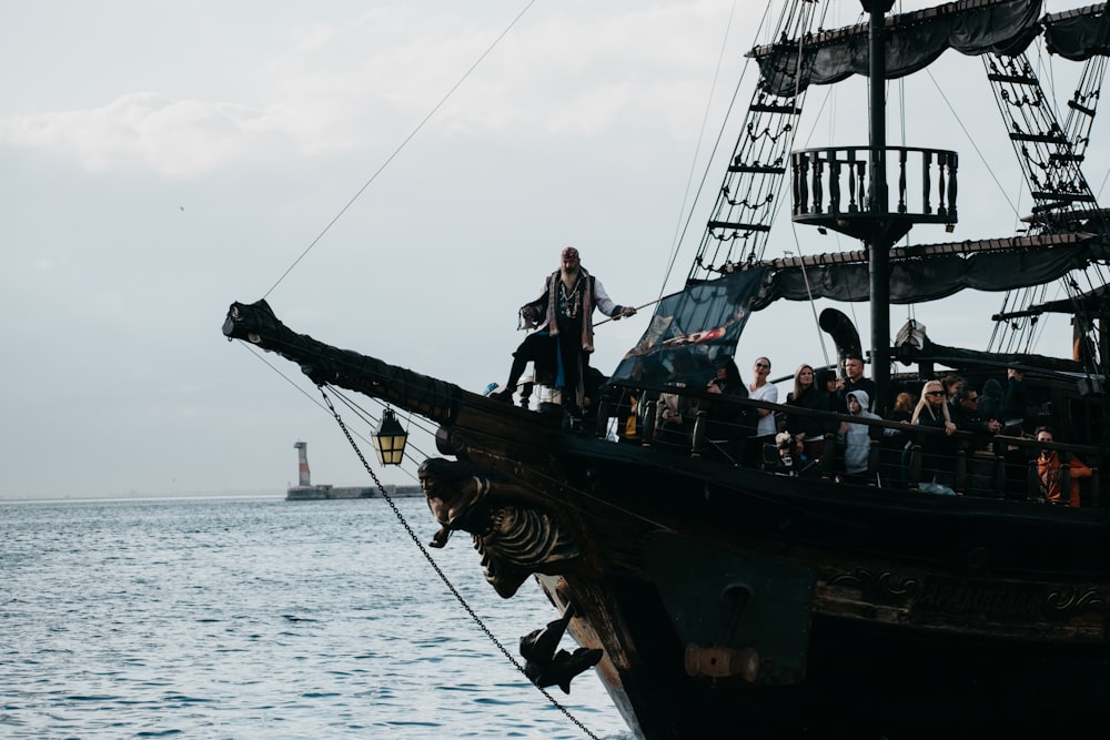 um grupo de pessoas em pé no topo de um navio pirata