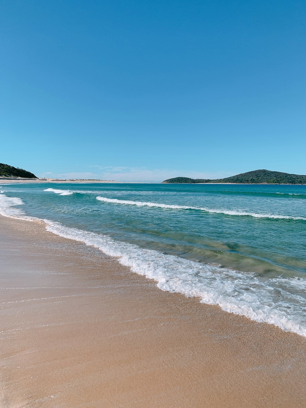 sea waves crashing on shore during daytime