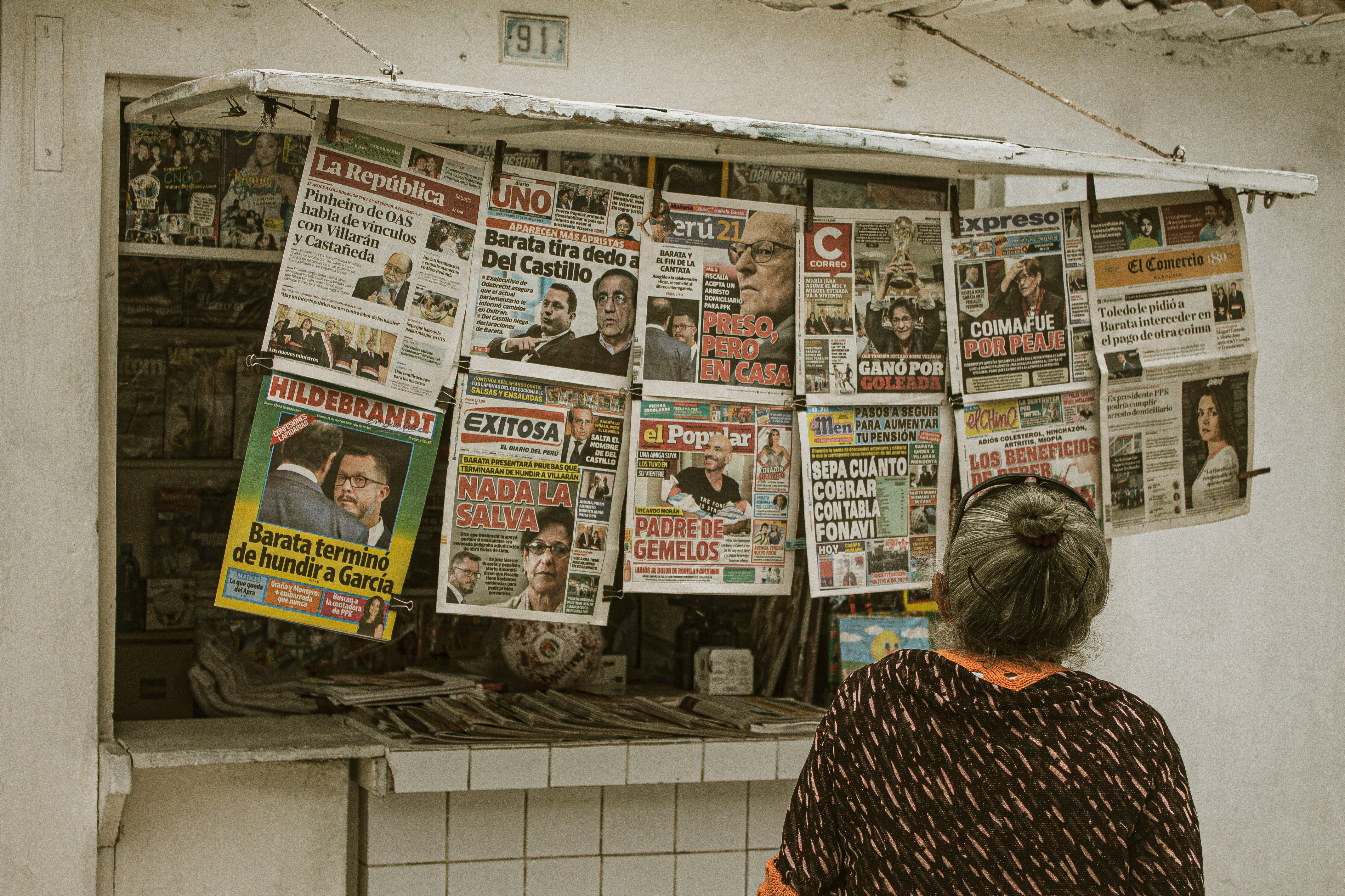 a woman standing in front of a newspaper stand