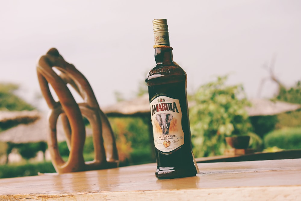 brown and black glass bottle on brown wooden table