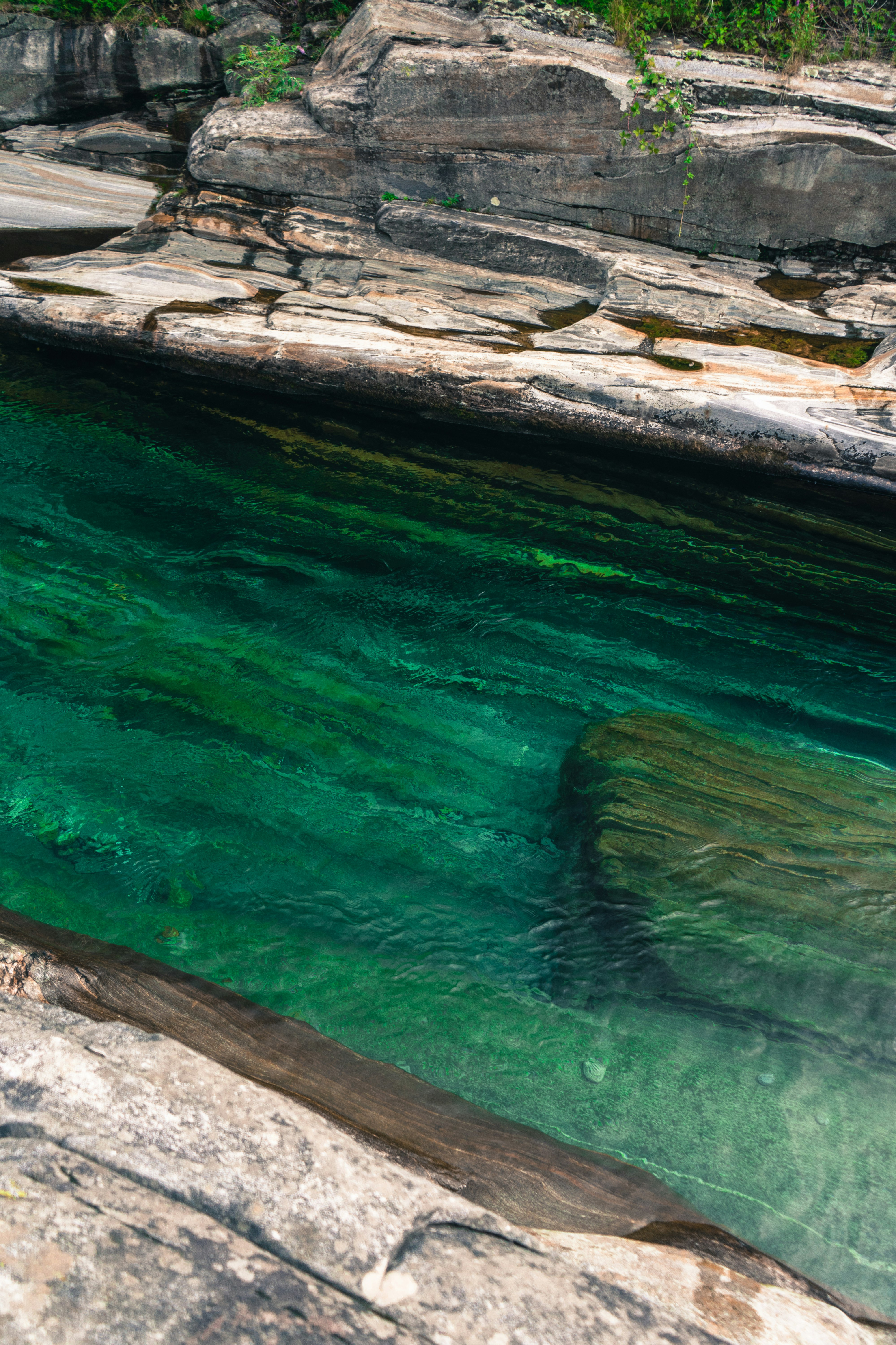 brown rock formation beside green water