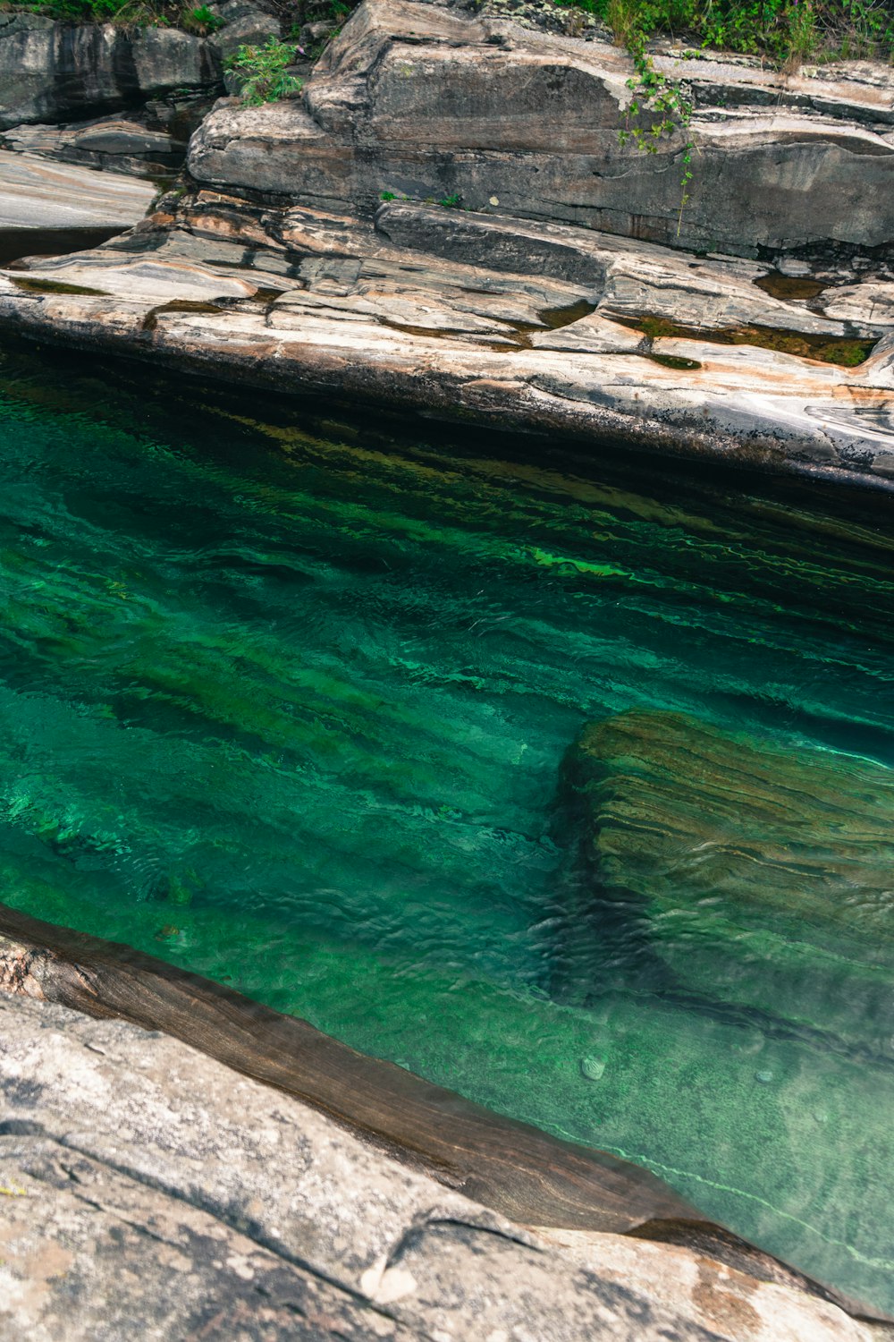 brown rock formation beside green water