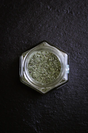 Clear glass jars filled with organic herbs and spices, showcasing sustainable packaging.