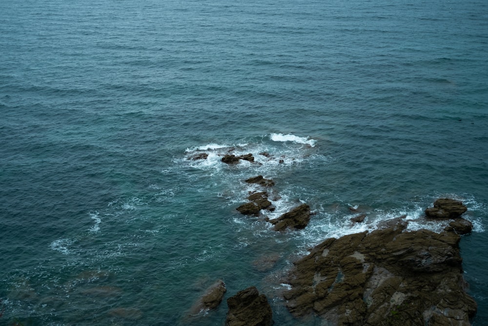 brown rocky shore with ocean waves during daytime