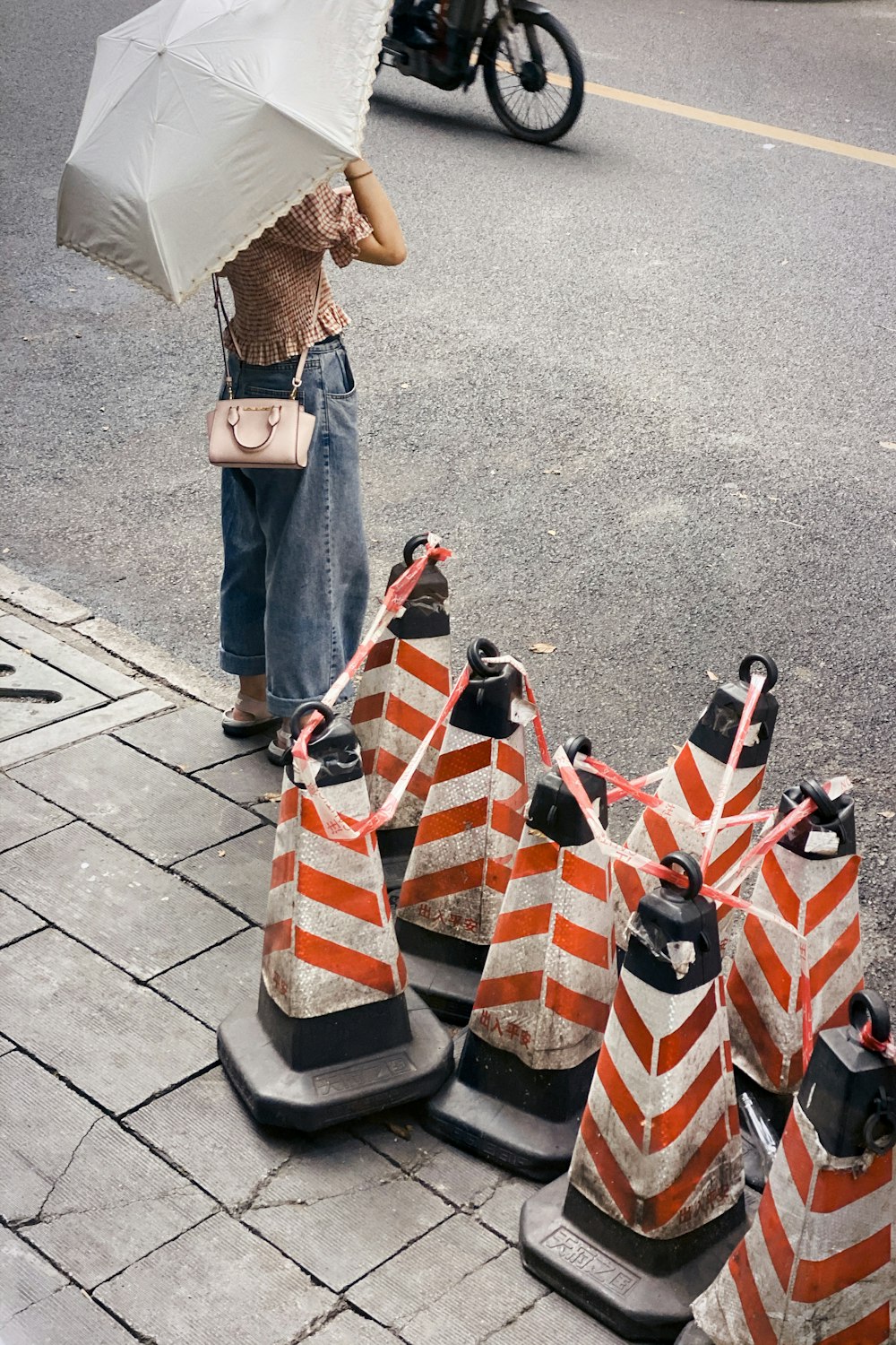 woman in blue denim jeans holding umbrella