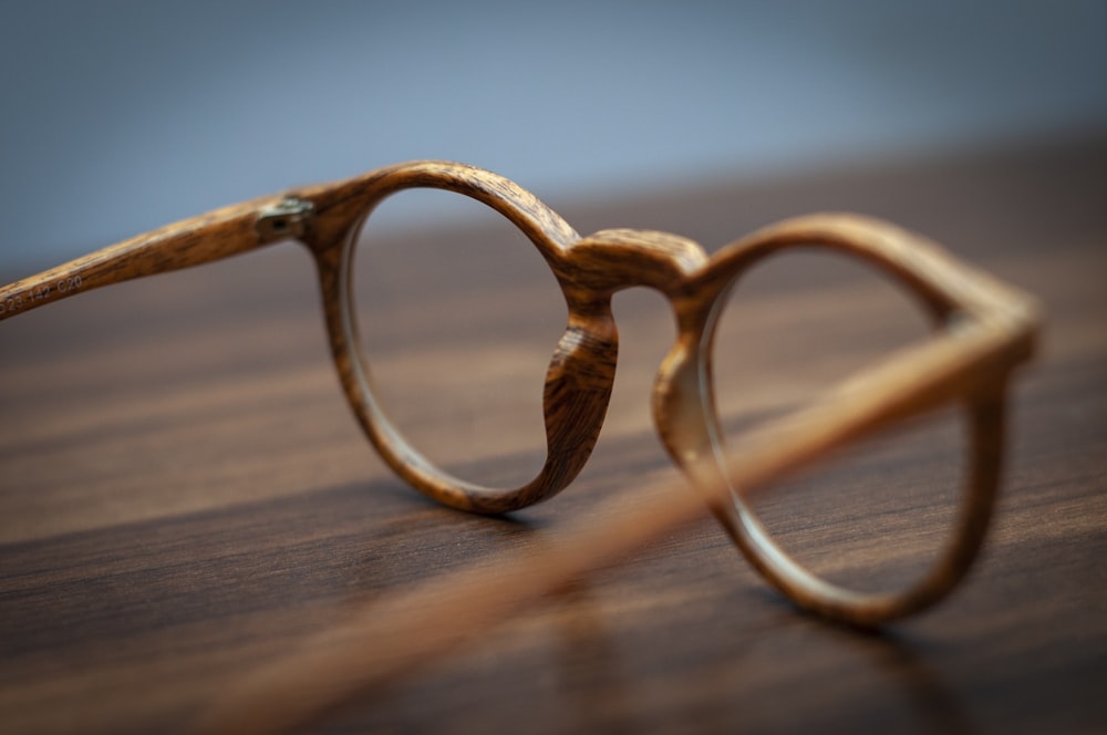 gold framed eyeglasses on brown wooden table