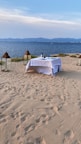 A couple enjoying a sunset dinner on a private beachside deck with elegant table settings.