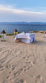 A couple enjoying a private dinner on the beach with elegant lanterns and ocean view.