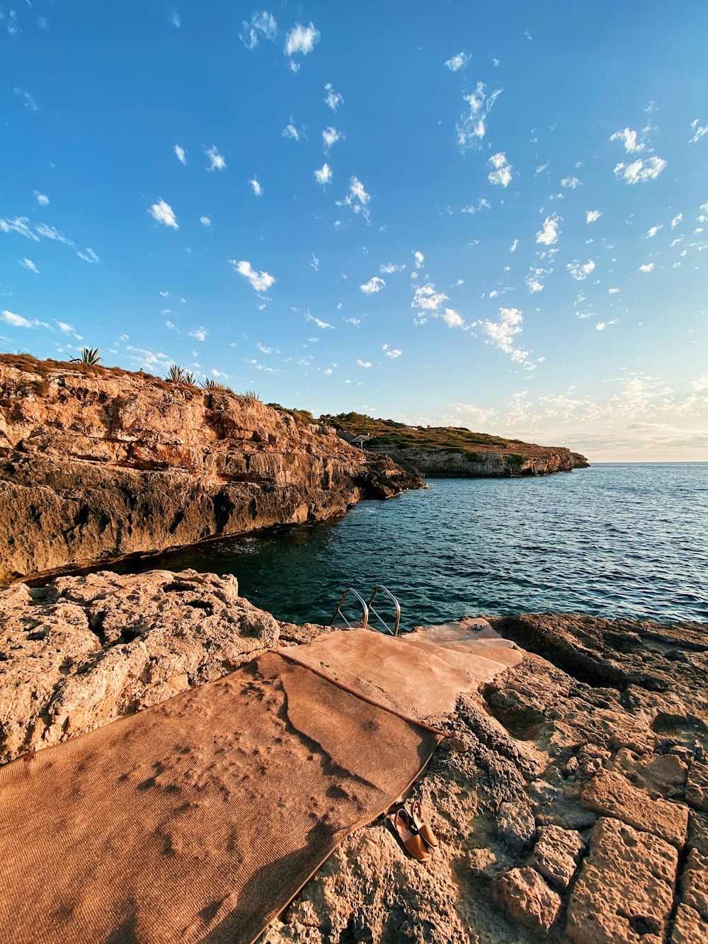 brown rock formation beside body of water during daytime