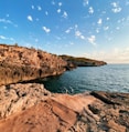 brown rock formation beside body of water during daytime