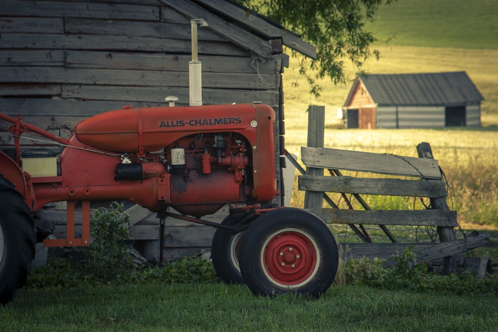 red tractor in front of brown wooden house
