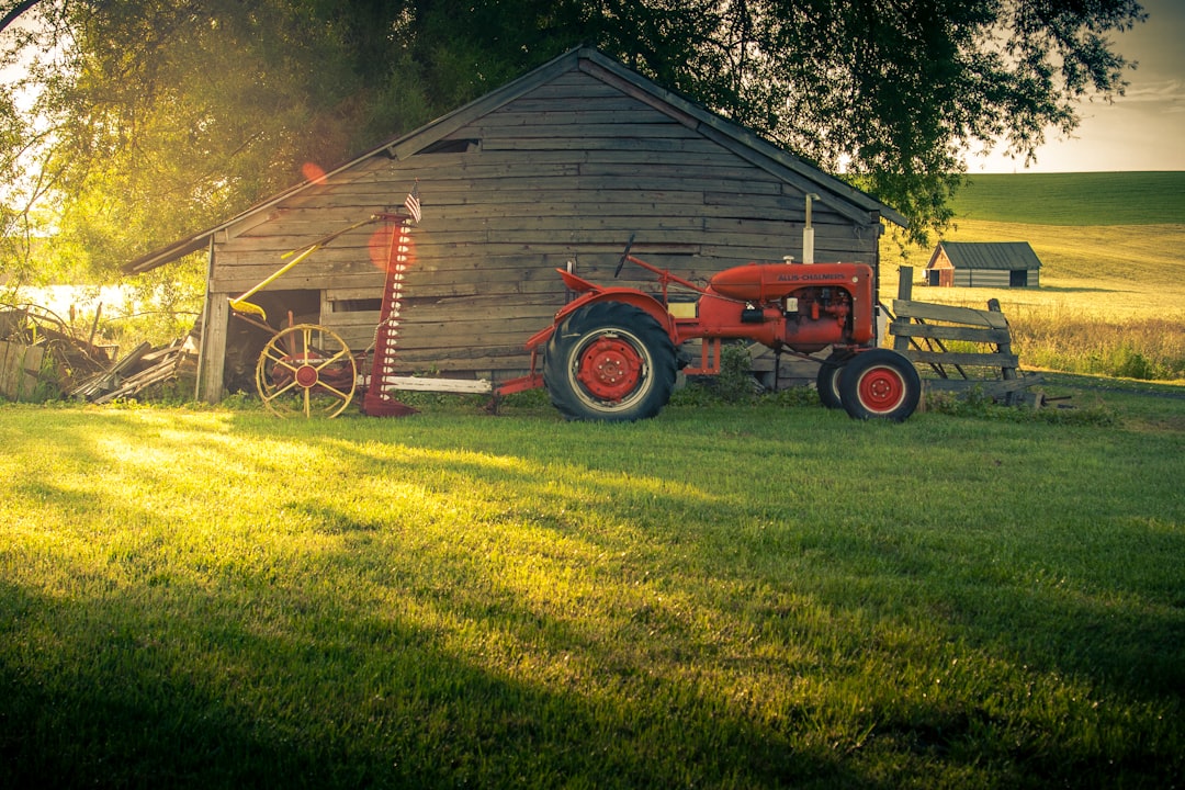 red tractor on green grass field during daytime