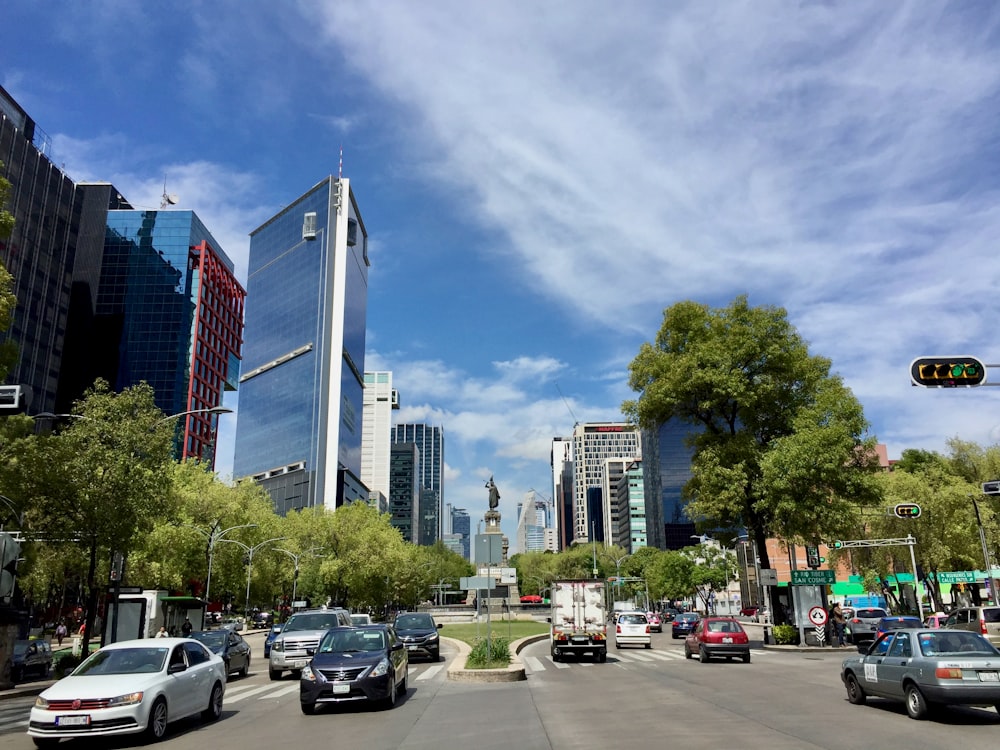 cars parked on parking lot near high rise buildings during daytime