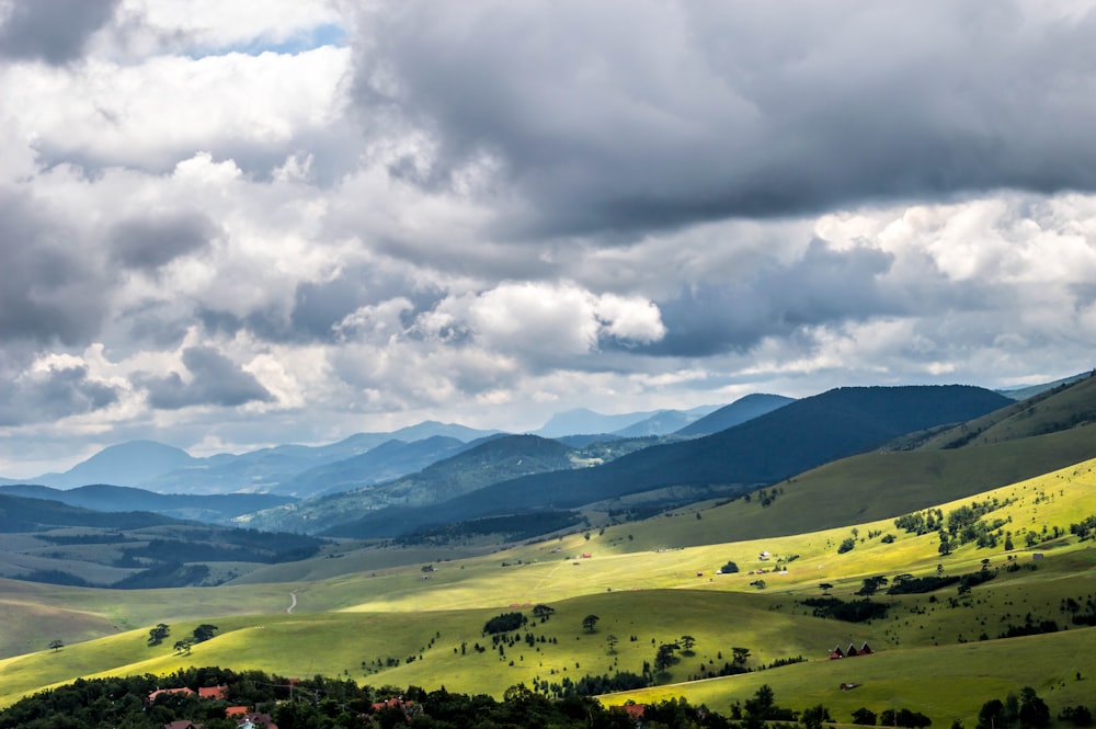 green grass field under white clouds during daytime